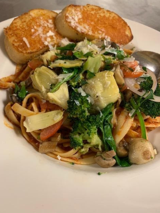 Two garlic bread with fresh pasta and veggies